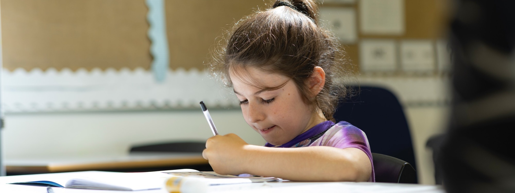 Student in a classroom writing